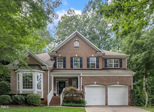 522 N Scotswood Blvd, Hillsborough, NC 27278 - view of front of property with an attached garage, concrete driveway, brick siding, and roof with shingles