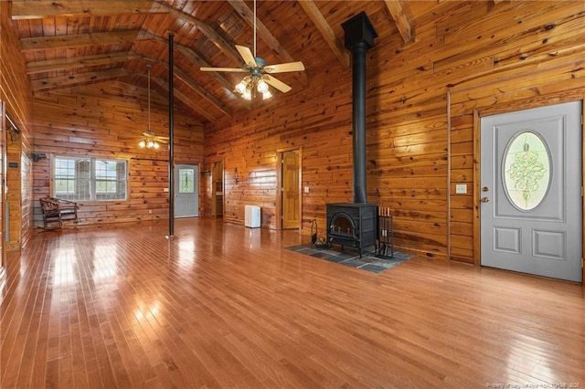 113 Atwood Ter, Stedman, NC 28391 - unfurnished living room featuring a wood stove, a ceiling fan, hardwood / wood-style flooring, wood walls, and wooden ceiling