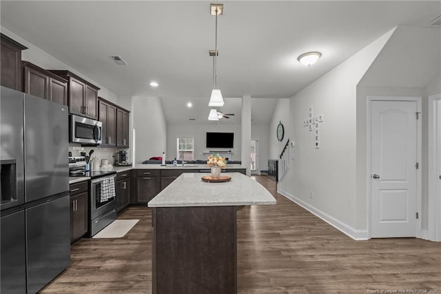 6752 Running Fox Rd, Hope Mills, NC 28348 - kitchen with stainless steel appliances, a center island, open floor plan, dark brown cabinets, and dark wood-style flooring