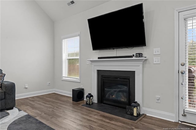 6752 Running Fox Rd, Hope Mills, NC 28348 - living area featuring wood finished floors, a glass covered fireplace, lofted ceiling, and baseboards