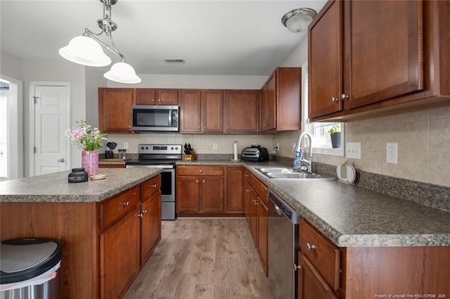 625 Fairfield Cir, Raeford, NC 28376 - kitchen with stainless steel appliances, a sink, light wood-style flooring, and brown cabinets