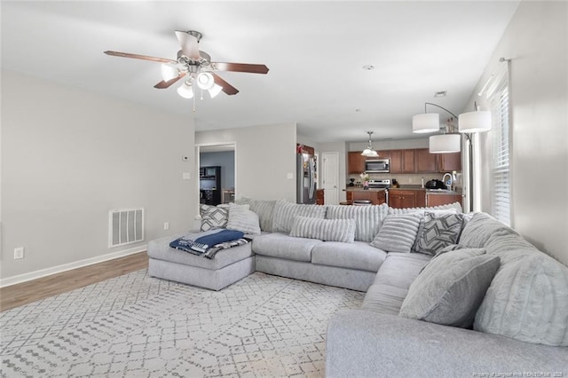 625 Fairfield Cir, Raeford, NC 28376 - living room featuring light wood finished floors, a ceiling fan, and baseboards