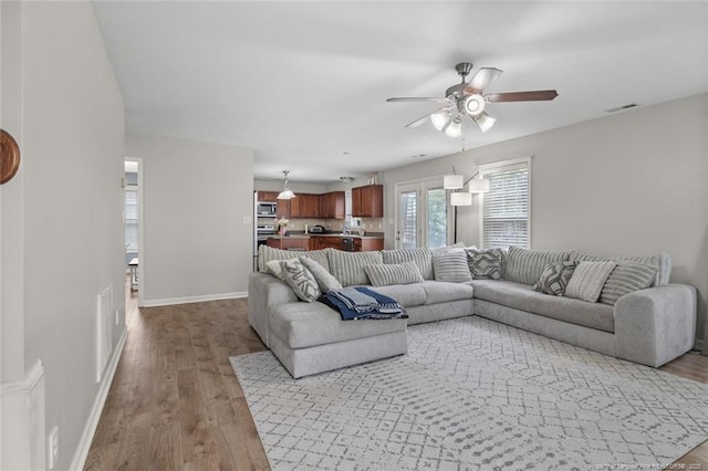 625 Fairfield Cir, Raeford, NC 28376 - living room featuring a ceiling fan, wood finished floors, and baseboards