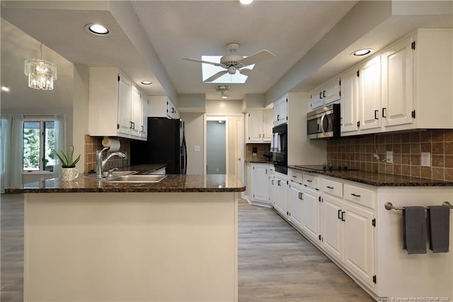 750 Mimosa Dr, Vass, NC 28394 - kitchen featuring a sink, black appliances, ceiling fan, a peninsula, and white cabinetry