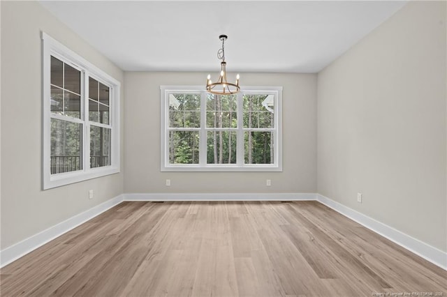 5400 Dowd Rd, West End, NC 27376 - unfurnished room with a chandelier, light wood-style floors, and baseboards
