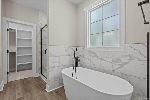 5400 Dowd Rd, West End, NC 27376 - bathroom with tile walls, wood finished floors, a shower stall, a freestanding tub, and a spacious closet