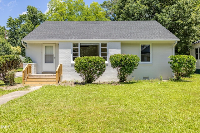 605 E Montgomery St, Henderson, NC 27536 - view of front of home featuring a shingled roof, a front yard, and brick siding