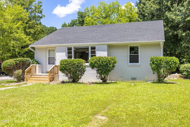 605 E Montgomery St, Henderson, NC 27536 - view of front of property with roof with shingles, a front lawn, and brick siding