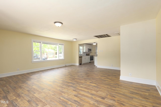 605 E Montgomery St, Henderson, NC 27536 - unfurnished living room featuring dark wood finished floors and baseboards