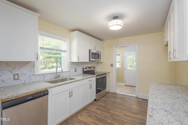 605 E Montgomery St, Henderson, NC 27536 - kitchen featuring appliances with stainless steel finishes, decorative backsplash, dark wood-style flooring, and plenty of natural light