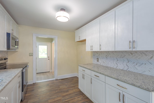 605 E Montgomery St, Henderson, NC 27536 - kitchen featuring stainless steel appliances, tasteful backsplash, white cabinets, and dark wood-style floors