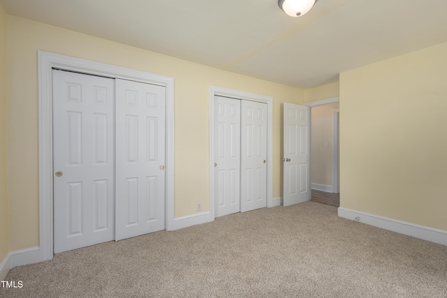 605 E Montgomery St, Henderson, NC 27536 - unfurnished bedroom featuring multiple closets and carpet floors
