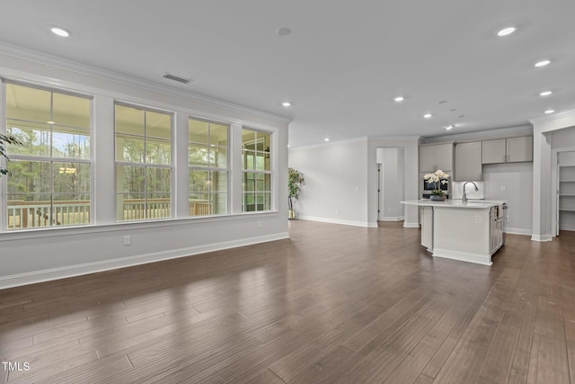 3020 Mavisbank Cir, Apex, NC 27502 - unfurnished living room featuring crown molding, recessed lighting, baseboards, dark wood-type flooring, and a sink