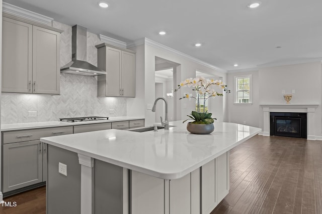 3020 Mavisbank Cir, Apex, NC 27502 - kitchen featuring wall chimney exhaust hood, gray cabinets, a sink, an island with sink, and gas cooktop