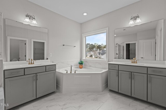 3020 Mavisbank Cir, Apex, NC 27502 - full bathroom featuring two vanities, a garden tub, marble finish flooring, a shower stall, and a walk in closet