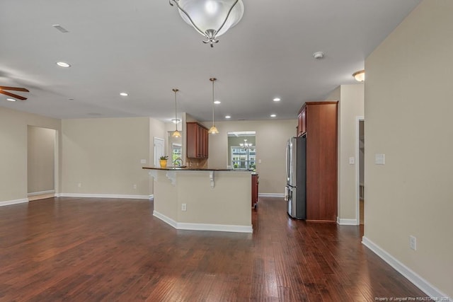 2240 Andalusian Dr, Hope Mills, NC 28348 - kitchen featuring freestanding refrigerator, a breakfast bar area, open floor plan, dark countertops, and recessed lighting