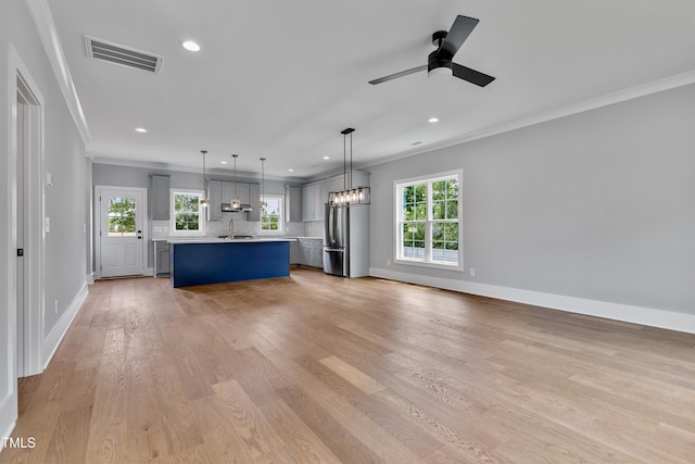 2521 Newbold St, Raleigh, NC 27603 - unfurnished living room with a sink, ornamental molding, baseboards, plenty of natural light, and recessed lighting