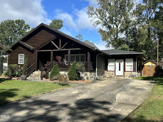 603 Hugo St, Durham, NC 27704 - view of front of house with covered porch, stone siding, a front lawn, concrete driveway, and log veneer siding
