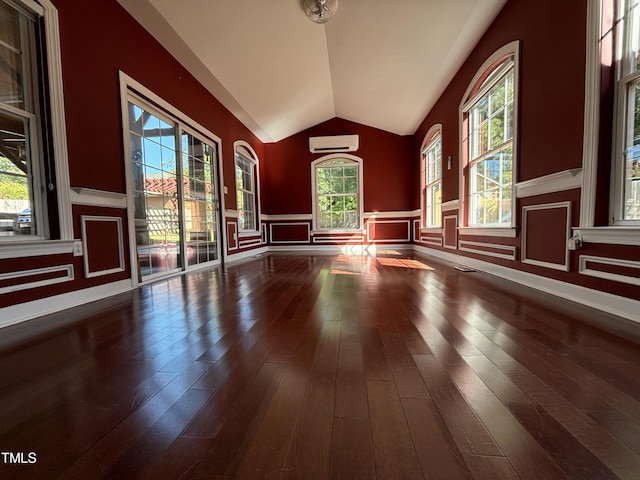 603 Hugo St, Durham, NC 27704 - spare room featuring a wall mounted AC, vaulted ceiling, and wood-type flooring
