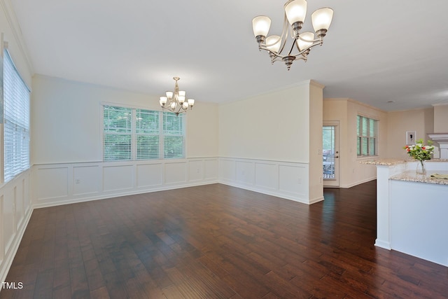 317 Springhurst Ln, Cary, NC 27511 - unfurnished dining area with a chandelier, dark wood-type flooring, plenty of natural light, a wainscoted wall, and a decorative wall