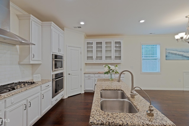 317 Springhurst Ln, Cary, NC 27511 - kitchen featuring wall chimney exhaust hood, a sink, stainless steel gas stovetop, crown molding, and white cabinets
