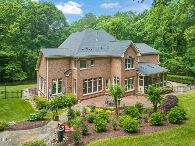 1317 Woodgate Manor Ct, Raleigh, NC 27614 - rear view of house featuring a sunroom, a patio, brick siding, and a shingled roof