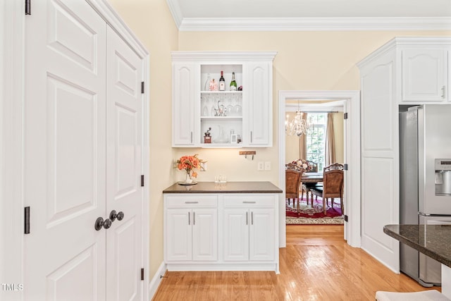 1317 Woodgate Manor Ct, Raleigh, NC 27614 - kitchen with stainless steel fridge with ice dispenser, ornamental molding, light wood-style flooring, white cabinetry, and dark stone counters