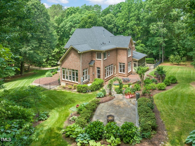 1317 Woodgate Manor Ct, Raleigh, NC 27614 - back of house featuring brick siding, a fire pit, a patio area, and a shingled roof