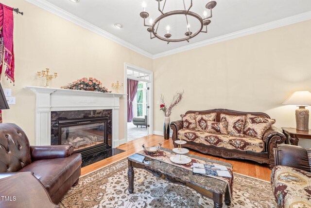 1317 Woodgate Manor Ct, Raleigh, NC 27614 - living room with wood finished floors, a chandelier, ornamental molding, and a high end fireplace