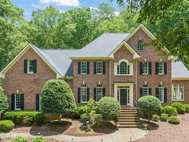 1317 Woodgate Manor Ct, Raleigh, NC 27614 - colonial inspired home featuring a shingled roof and brick siding