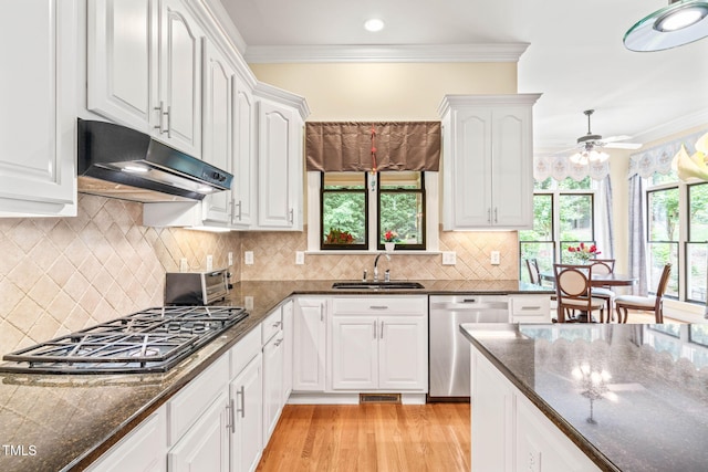 1317 Woodgate Manor Ct, Raleigh, NC 27614 - kitchen featuring stainless steel dishwasher, under cabinet range hood, gas cooktop, white cabinets, and crown molding