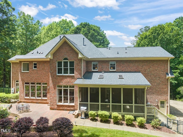 1317 Woodgate Manor Ct, Raleigh, NC 27614 - rear view of house featuring a sunroom, a patio, brick siding, and a shingled roof
