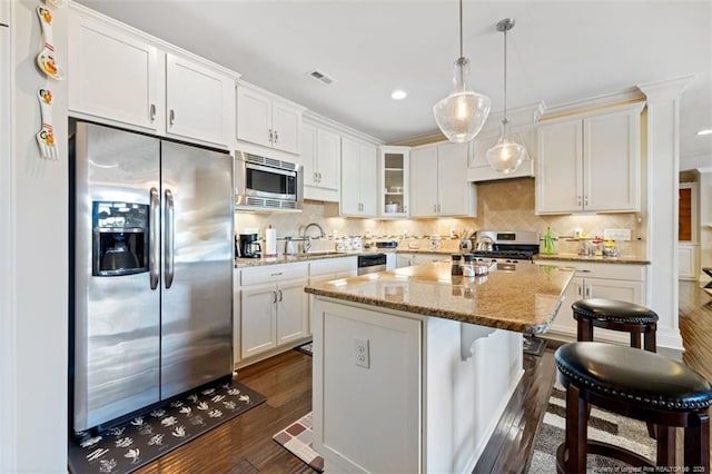 220 Hugh Shelton Loop, Fayetteville, NC 28303 - kitchen with appliances with stainless steel finishes, dark wood-type flooring, white cabinets, a center island, and glass insert cabinets