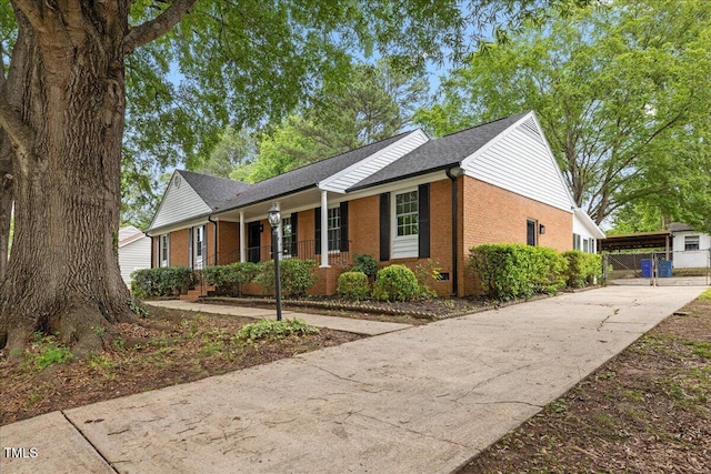 5110 Old Well St, Durham, NC 27704 - view of front of house with brick siding, a porch, driveway, and a shingled roof