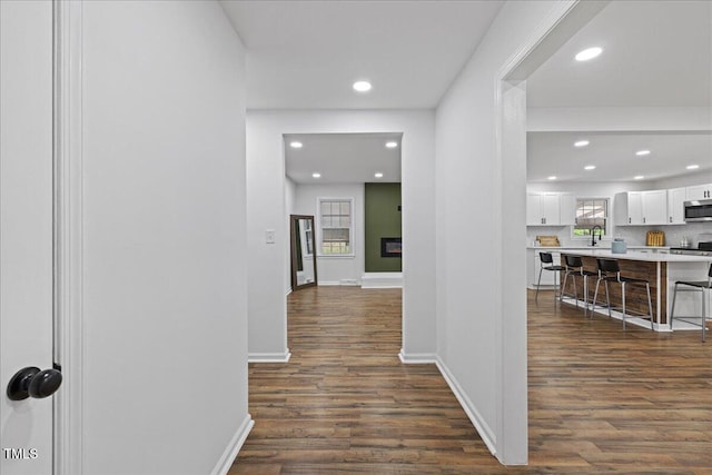 5110 Old Well St, Durham, NC 27704 - hallway featuring dark wood finished floors, recessed lighting, baseboards, and a sink
