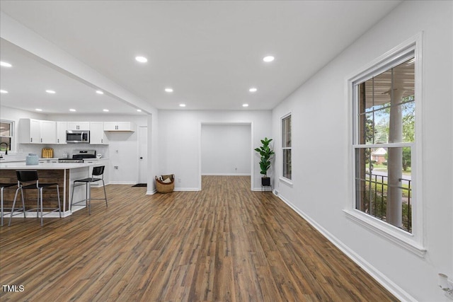 5110 Old Well St, Durham, NC 27704 - living area with dark wood finished floors, baseboards, and recessed lighting
