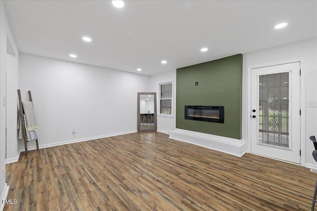5110 Old Well St, Durham, NC 27704 - unfurnished living room with wood finished floors, recessed lighting, a glass covered fireplace, and baseboards