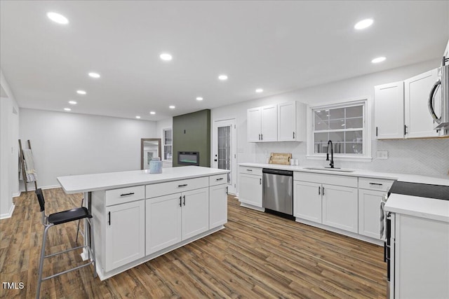 5110 Old Well St, Durham, NC 27704 - kitchen with appliances with stainless steel finishes, a sink, dark wood finished floors, a kitchen island, and recessed lighting