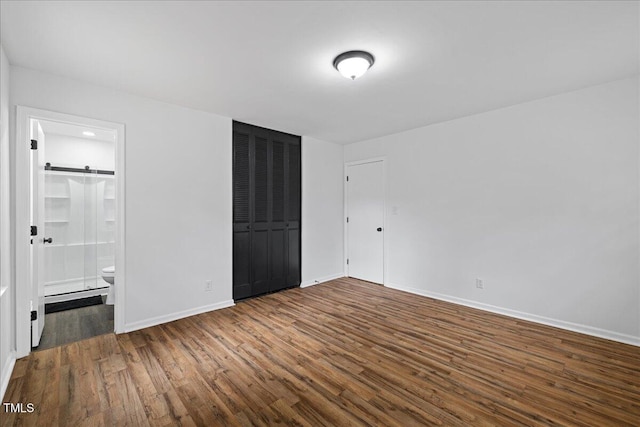 5110 Old Well St, Durham, NC 27704 - unfurnished bedroom featuring wood finished floors, baseboards, connected bathroom, and a closet