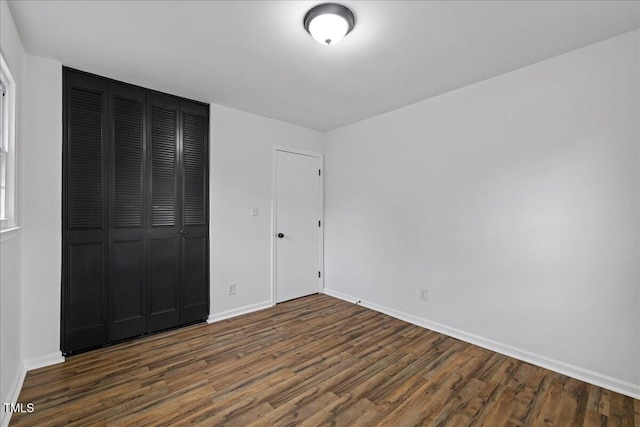 5110 Old Well St, Durham, NC 27704 - unfurnished bedroom with dark wood-style floors, baseboards, and a closet