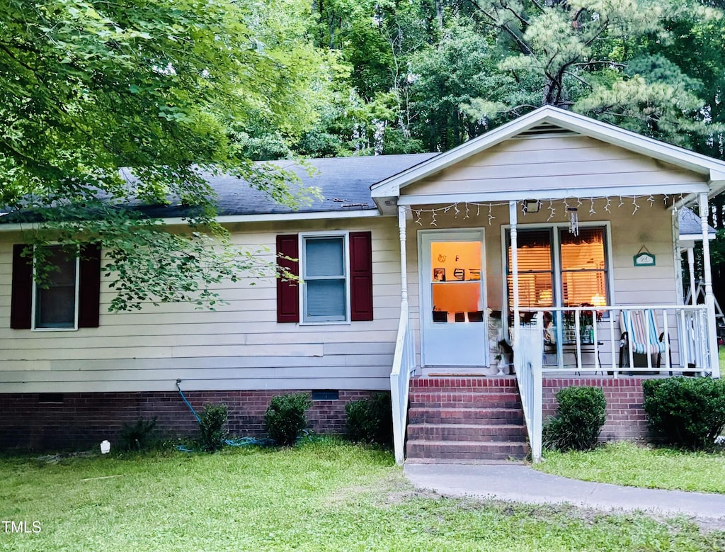 109 Grange Dr, Wendell, NC 27591 - bungalow-style house featuring crawl space, covered porch, a front lawn, and a shingled roof