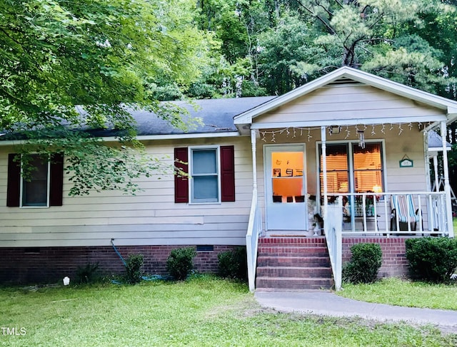 109 Grange Dr, Wendell, NC 27591 - bungalow-style house featuring crawl space, covered porch, a front lawn, and a shingled roof