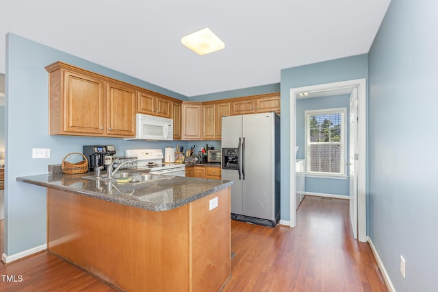 6 N Carolina Ave, Benson, NC 27504 - kitchen with white appliances, a sink, wood finished floors, a peninsula, and baseboards