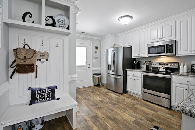3501 Cranberry Ridge Dr SW, Wilson, NC 27893 - kitchen with appliances with stainless steel finishes, white cabinetry, wood finished floors, ornamental molding, and dark stone counters