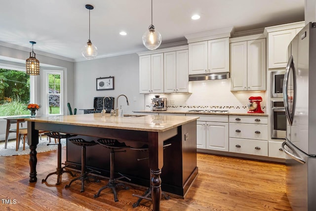 201 Margaret Mann Way, Pittsboro, NC 27312 - kitchen with a sink, appliances with stainless steel finishes, crown molding, white cabinetry, and a breakfast bar