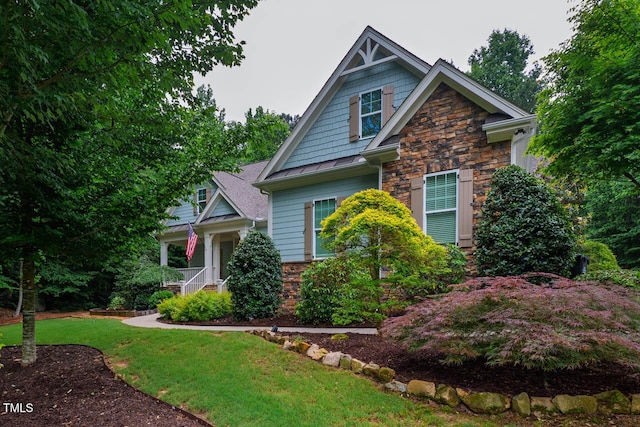 201 Margaret Mann Way, Pittsboro, NC 27312 - craftsman-style house with stone siding, a front lawn, a standing seam roof, and covered porch