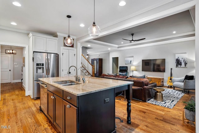 201 Margaret Mann Way, Pittsboro, NC 27312 - kitchen featuring a sink, appliances with stainless steel finishes, ceiling fan, light wood-style floors, and light stone countertops