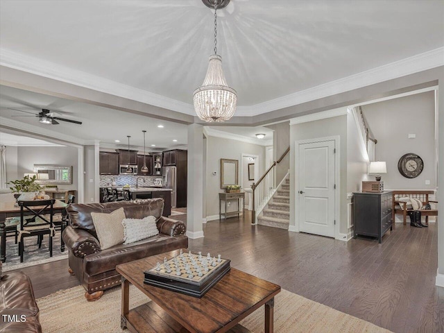 374 Crimson Way, Pittsboro, NC 27312 - living room featuring stairway, wood finished floors, a ceiling fan, a chandelier, and crown molding