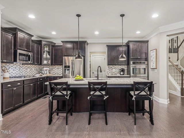 374 Crimson Way, Pittsboro, NC 27312 - kitchen featuring stainless steel appliances, tasteful backsplash, wood finished floors, dark brown cabinetry, and a breakfast bar area
