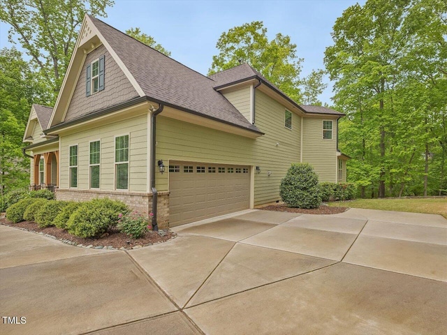 374 Crimson Way, Pittsboro, NC 27312 - view of side of property featuring driveway, an attached garage, brick siding, and a shingled roof